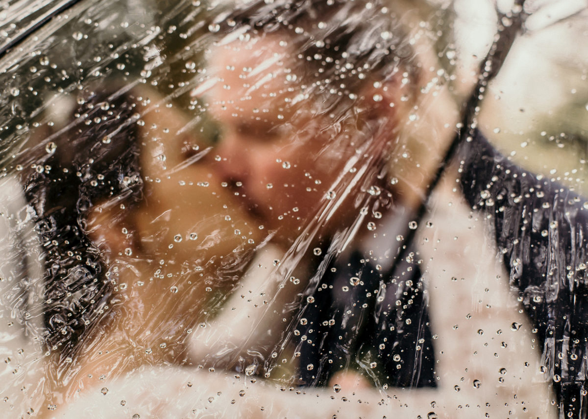 brudpar, kyss, bröllopsdag, regnar på bröllopsdagen, genomskinligt paraply, bröllopsfotograf, Helsingborg, Skåne, Norrvikens Trädgårdar